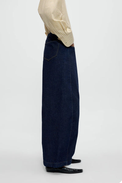 Zijaanzicht van de CORDERA Curved Baggy Jeans met gebogen pijpen en oversized pasvorm in donkere denim